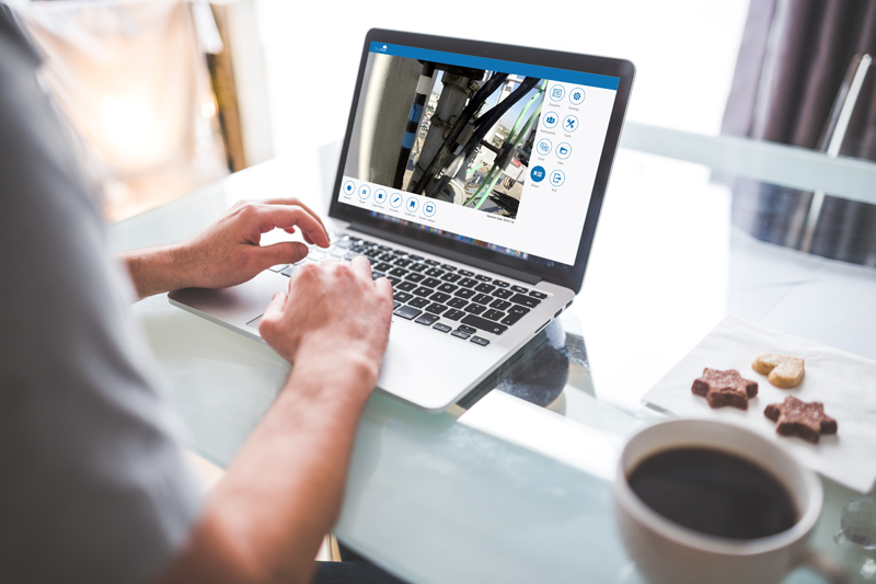 person sits at desk with coffee and laptop at work