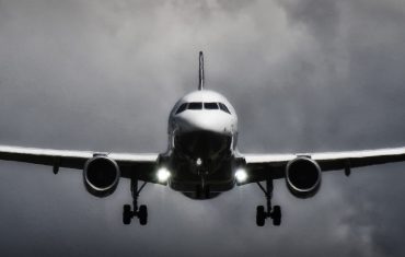 plane flying in dark cloudy sky