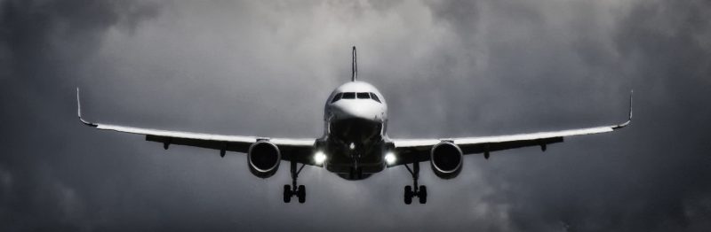 plane flying in dark cloudy sky